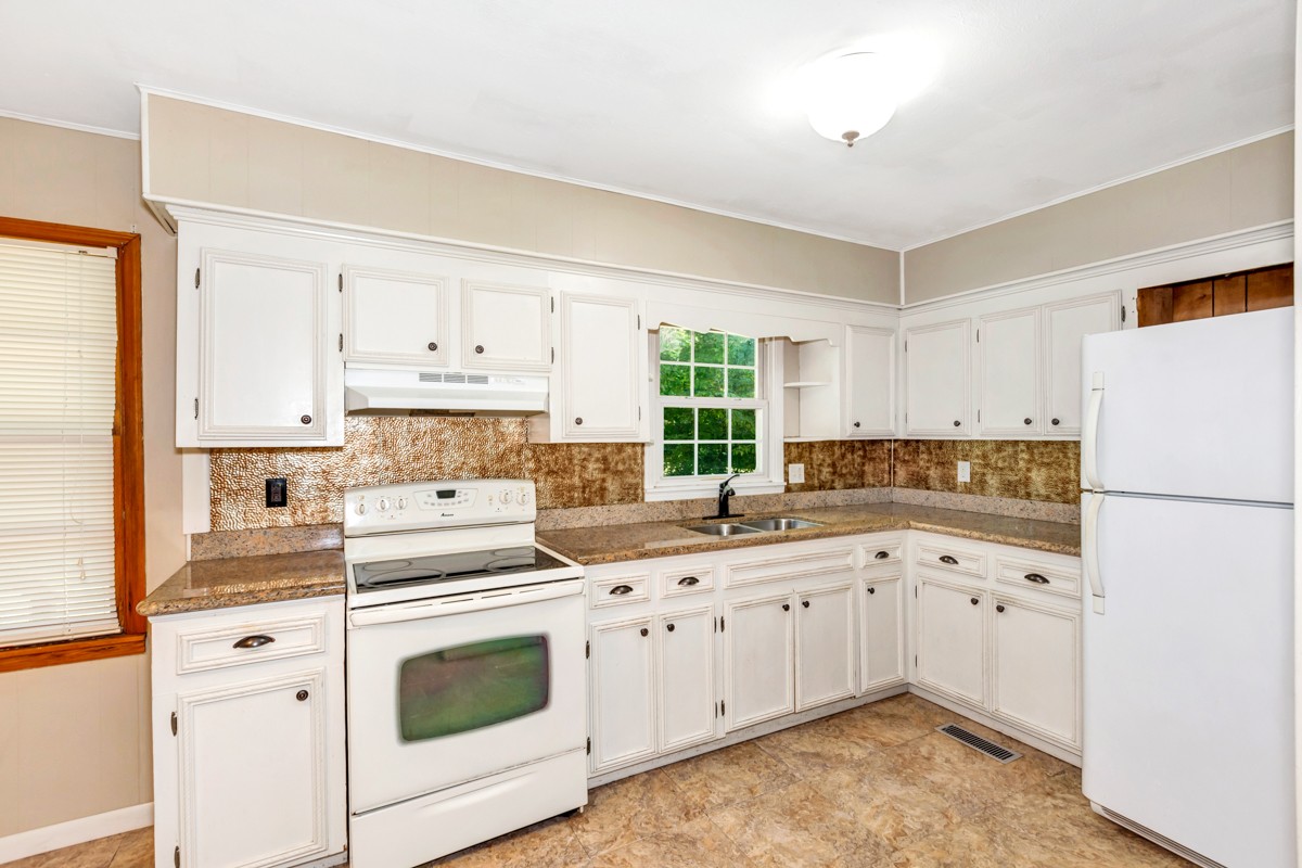 1758 Old Stage Road Ardmore, TN 38449 - Photo 13 of 25 a kitchen with white cabinets sink and white appliances