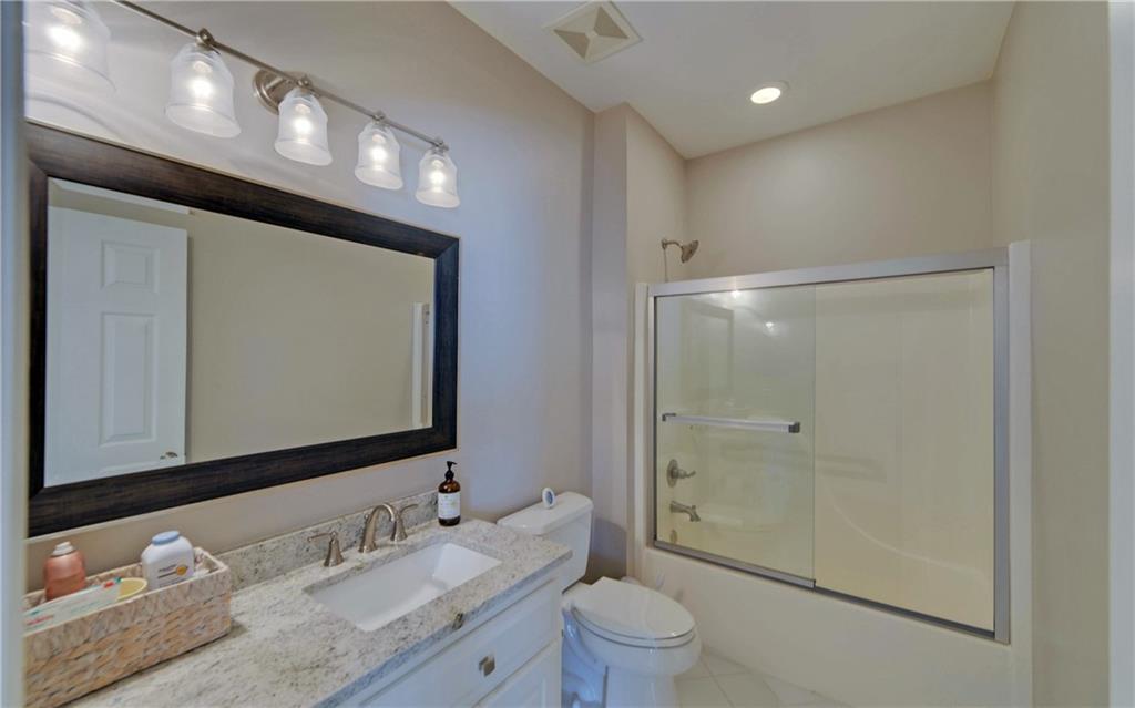 2760 Camp Branch Road Buford, GA 30519 - Photo 48 of 73 a bathroom with a granite countertop sink a toilet and a large mirror