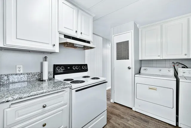 a kitchen with granite countertop white cabinets stainless steel appliances and sink