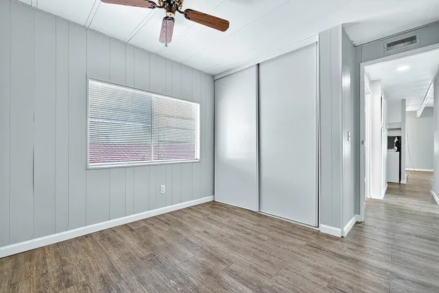 a view of a livingroom with wooden floor and a ceiling fan