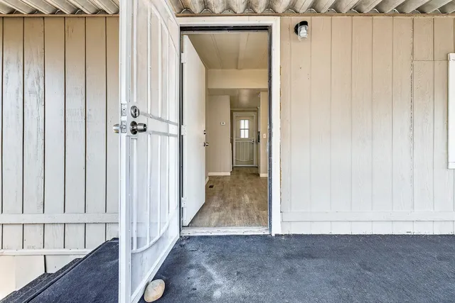 a view of a hallway with wooden floor and entryway