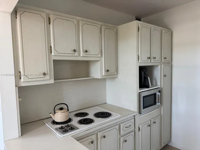 a kitchen with white cabinets and a stove
