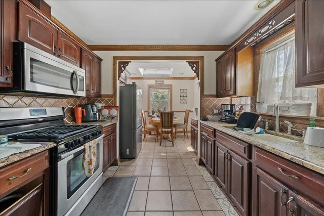 a kitchen with stainless steel appliances granite countertop a stove a sink and a microwave