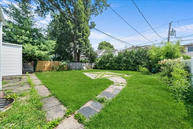 a view of a house with backyard and a tree