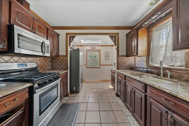 a kitchen with stainless steel appliances granite countertop a stove a sink and a microwave