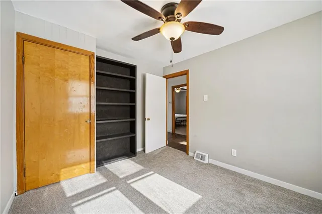 a view of an empty room with a ceiling fan