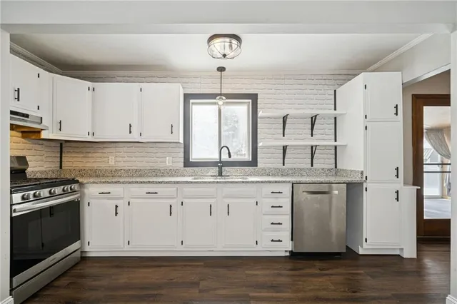 a kitchen with granite countertop white cabinets and white appliances