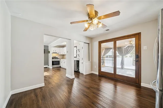 a view of an empty room with a window and wooden floor