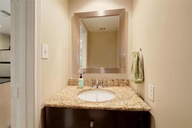 a bathroom with a granite countertop sink and a mirror