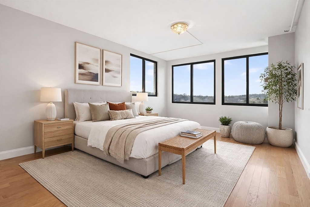 1731 Beacon Street, Unit 1210 Brookline, MA 02445 - Photo 11 of 32 a bedroom with a bed and glass window