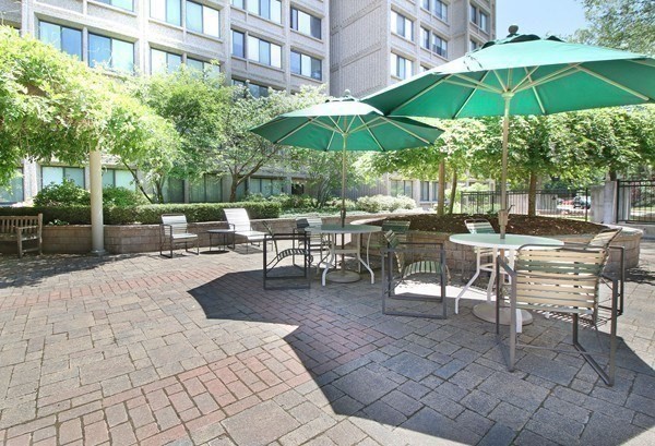 1731 Beacon Street, Unit 1210 Brookline, MA 02445 - Photo 23 of 32 a view of a patio with a table and chairs under an umbrella