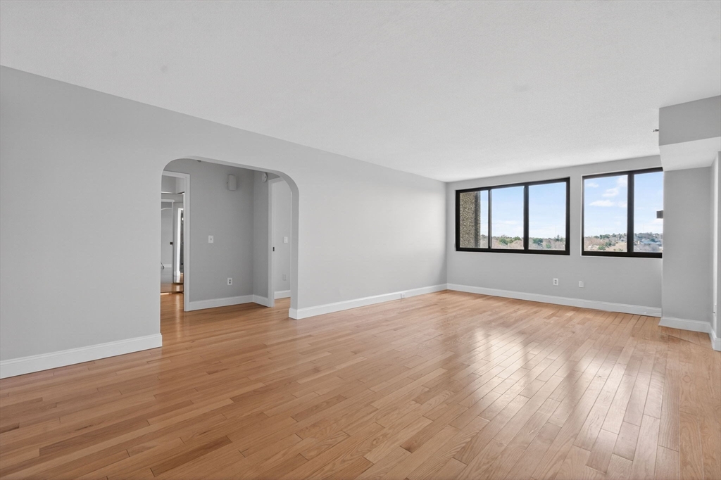 1731 Beacon Street, Unit 1210 Brookline, MA 02445 - Photo 4 of 32 a view of an empty room with wooden floor and a window