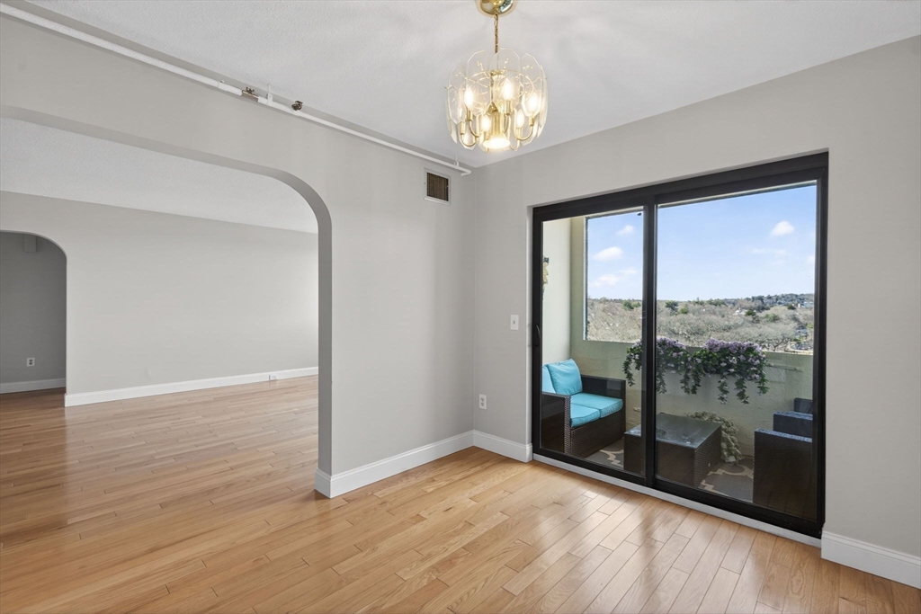 1731 Beacon Street, Unit 1210 Brookline, MA 02445 - Photo 7 of 32 a view of an empty room with wooden floor and a window