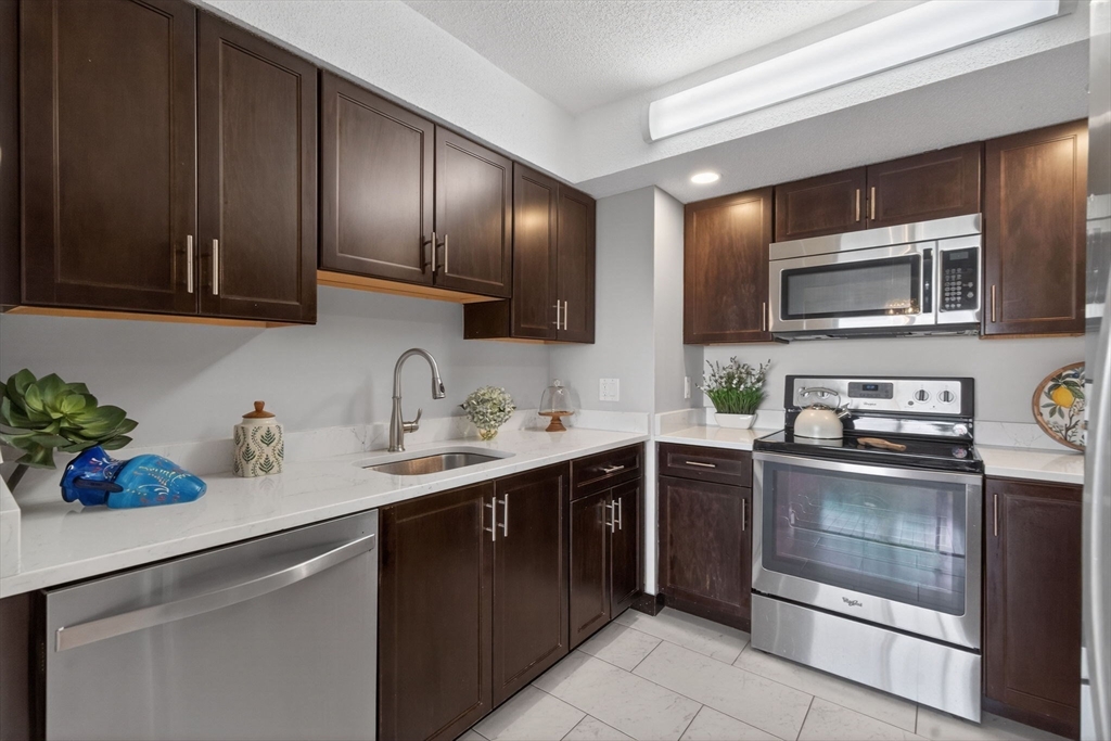1731 Beacon Street, Unit 1210 Brookline, MA 02445 - Photo 9 of 32 a kitchen with a sink cabinets and stainless steel appliances