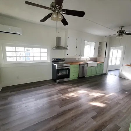 a kitchen with stainless steel appliances granite countertop a stove top oven a sink with wooden floors