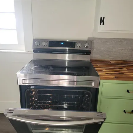 a stove top oven sitting inside of a kitchen