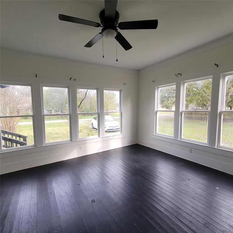 410 Southwest 3rd Street Kerens, TX 75144 - Photo 6 of 21 an empty room with wooden floor and windows