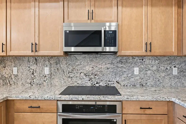 a kitchen with granite countertop a stove and a microwave
