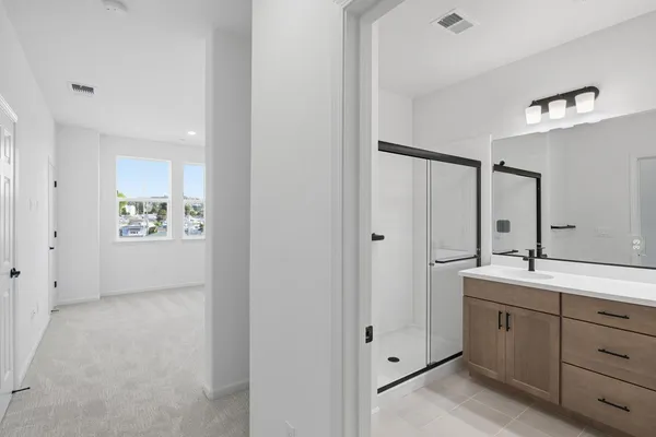 a spacious bathroom with a double vanity sink a mirror and a shower