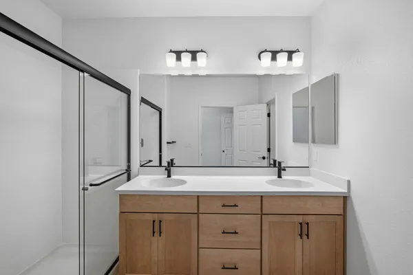 a bathroom with a double vanity sink mirror and