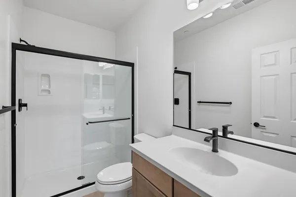 a bathroom with a sink toilet a mirror and shower