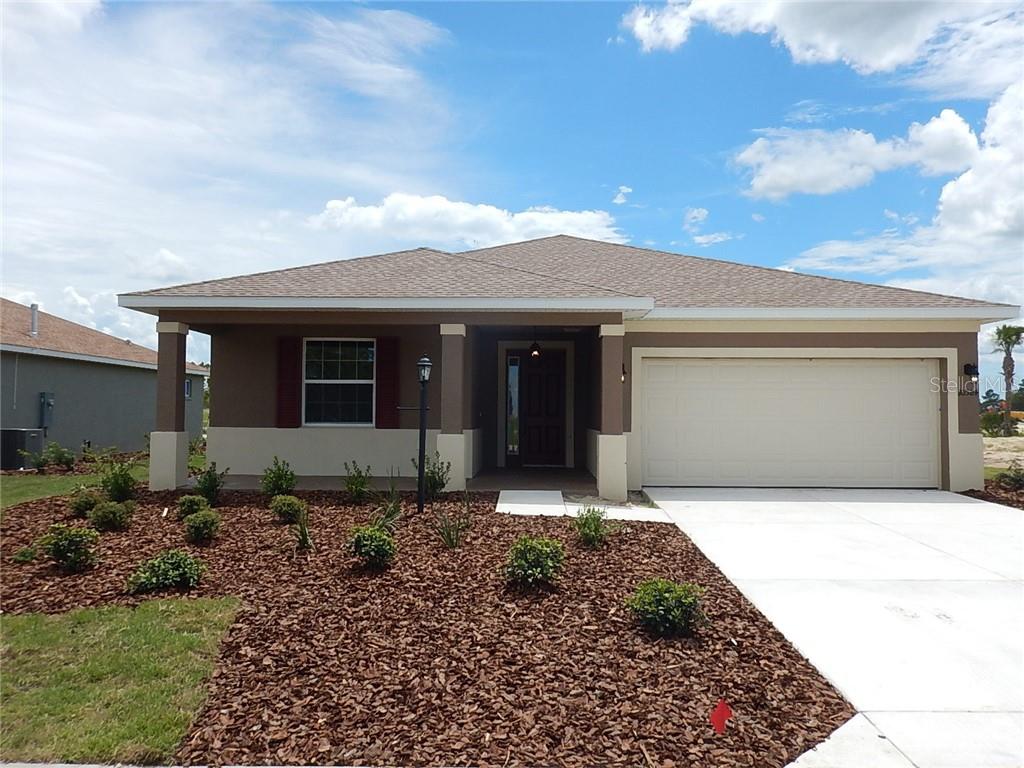 a front view of a house with a garden and plants