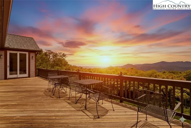 a kitchen with stainless steel appliances granite countertop a stove top oven a refrigerator a dining table and chairs with wooden floor