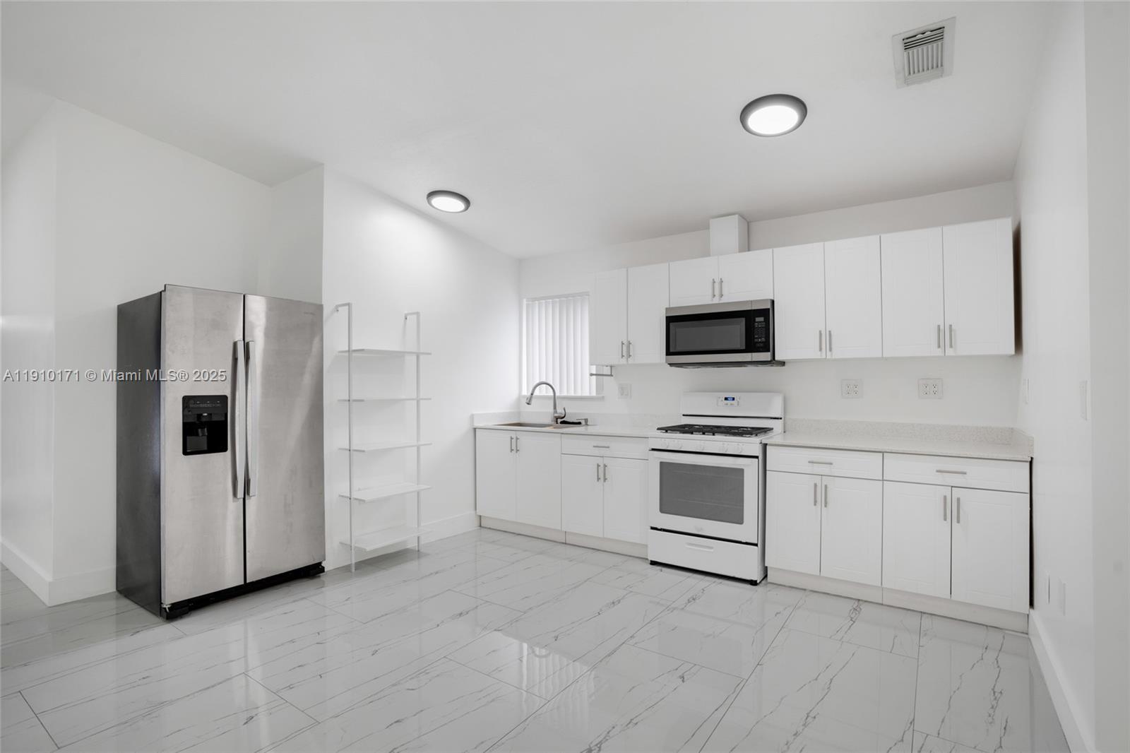 12068 Southwest 210th Street Miami, FL 33177 - Photo 4 of 19 a kitchen with white cabinets and white appliances