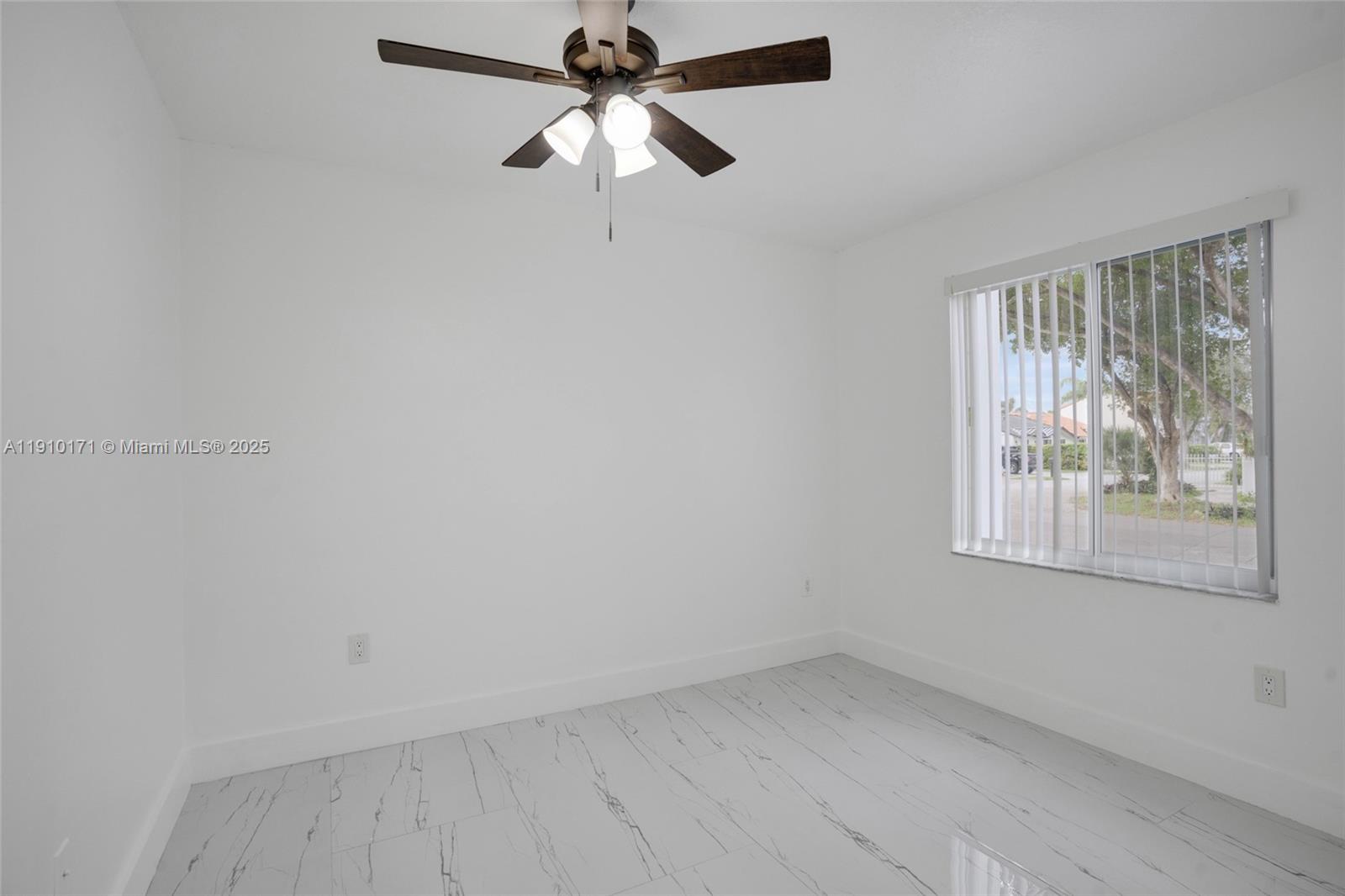 12068 Southwest 210th Street Miami, FL 33177 - Photo 9 of 19 an empty room with a window and a fan