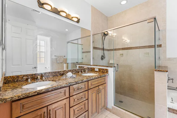 a bathroom with a granite countertop sink a mirror and shower