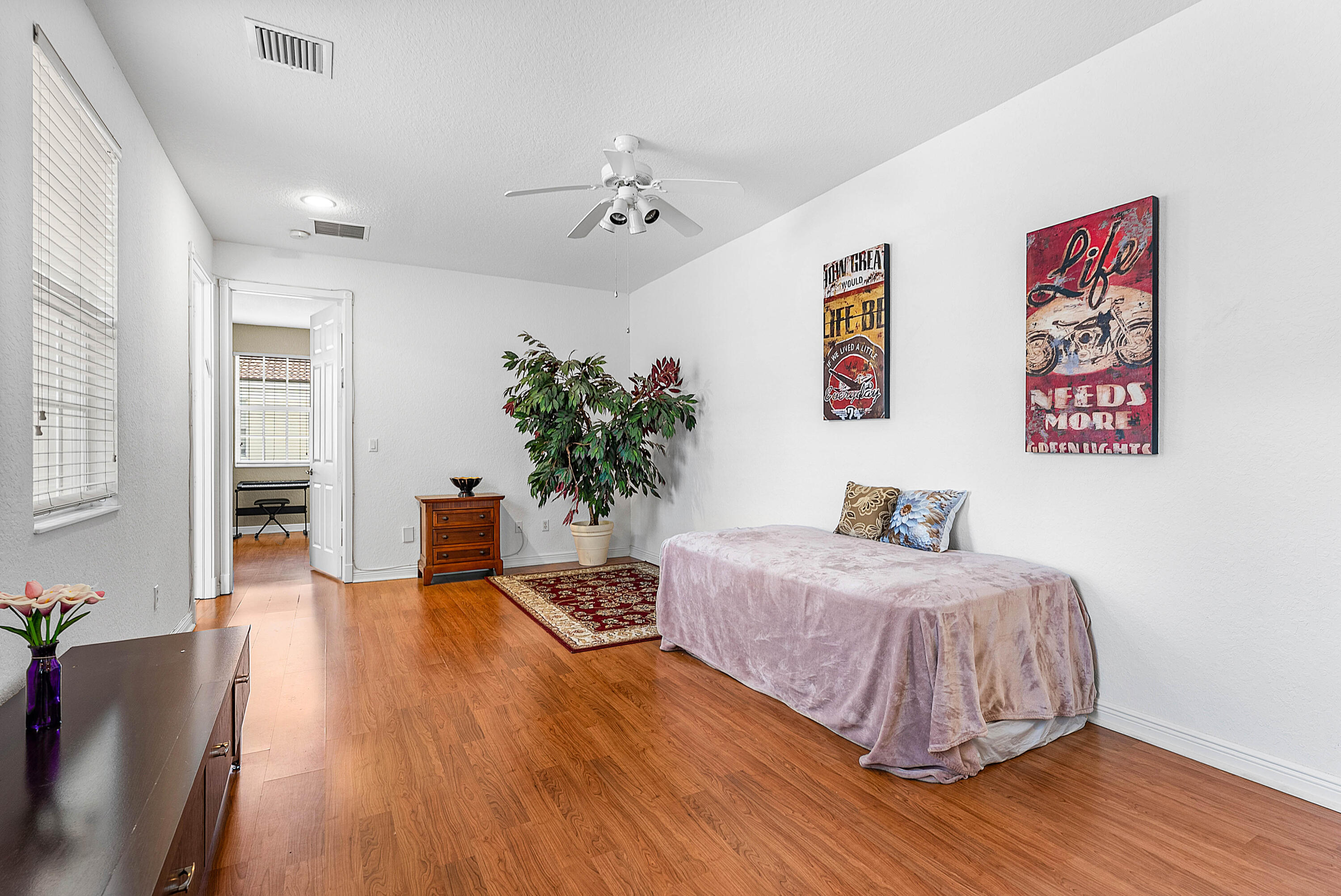 8309 Northwest 8th Way Boca Raton, FL 33487 - Photo 25 of 39 a bedroom with a large bed chandelier and a wooden floor