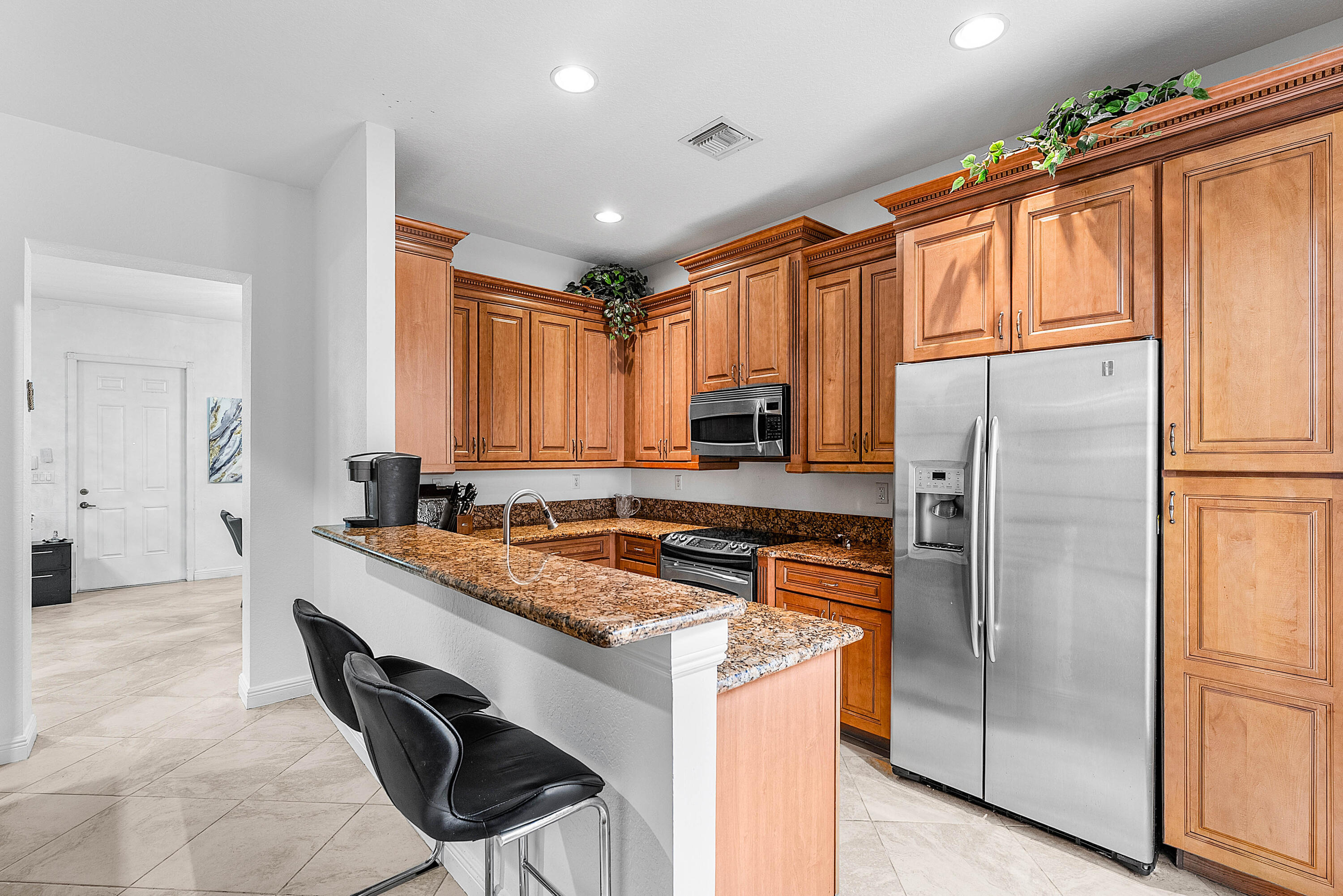 8309 Northwest 8th Way Boca Raton, FL 33487 - Photo 9 of 39 a kitchen with stainless steel appliances granite countertop a refrigerator a stove and a sink
