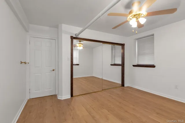an empty room with closet and a chandelier fan