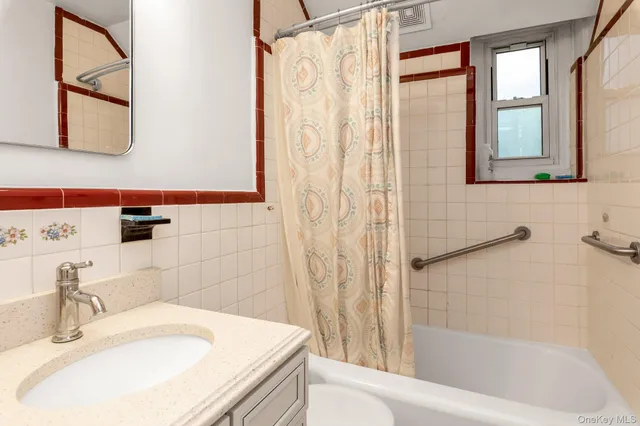 a bathroom with a granite countertop sink and a bathtub