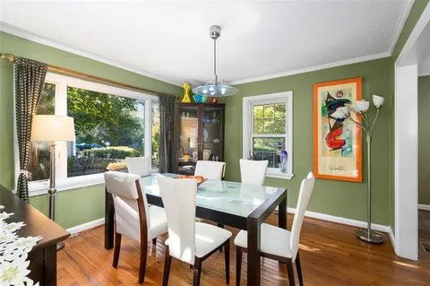 a view of a dining room with furniture a chandelier and wooden floor