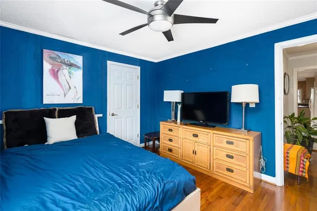a bedroom with a bed and a flat tv screen on dresser