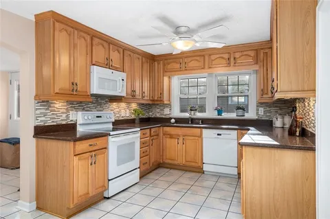 a kitchen with stainless steel appliances granite countertop a stove a sink and a microwave