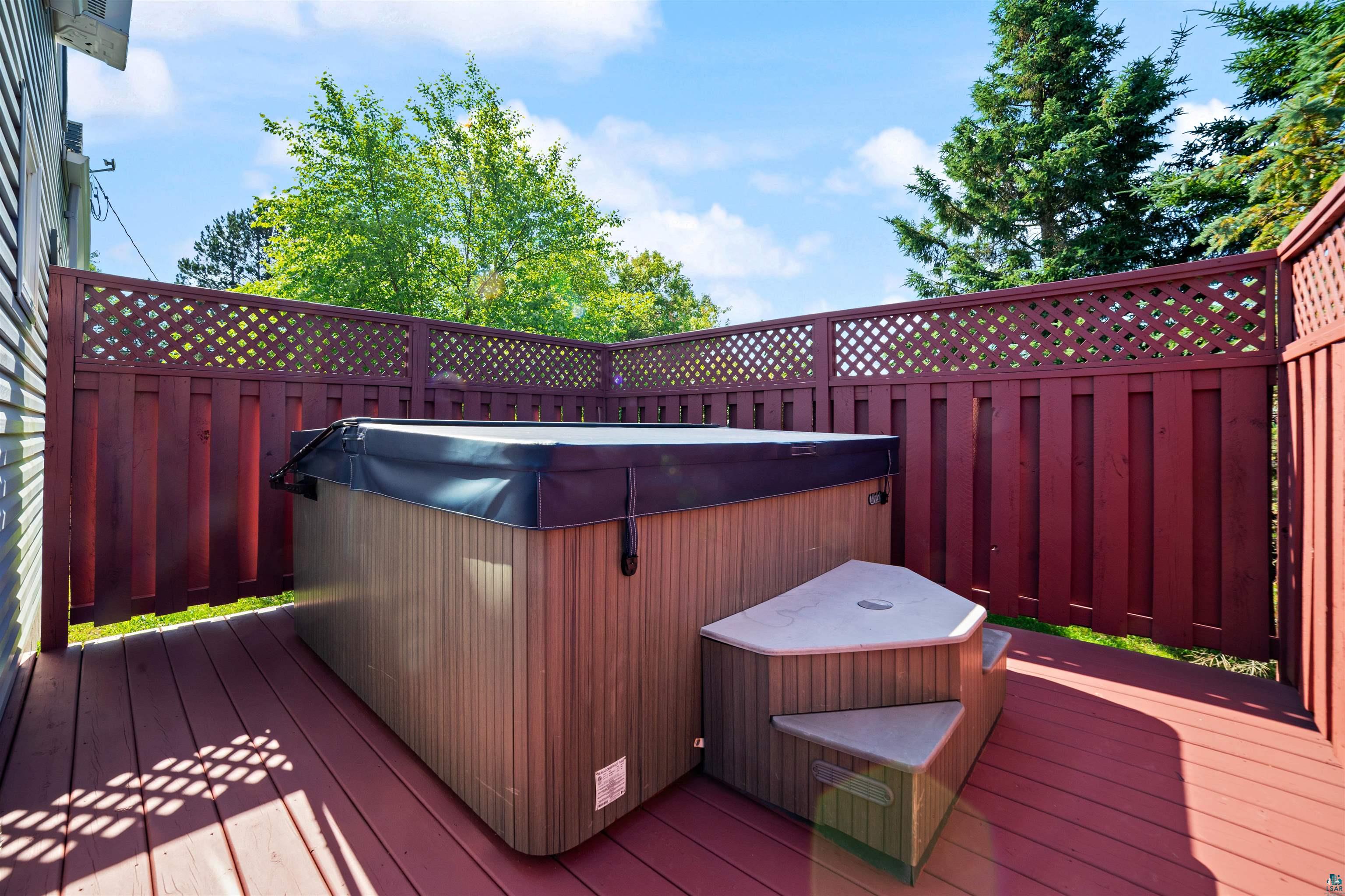 4073 Reinke Road Duluth, MN 55811 - Photo 22 of 32 Outdoor spa with a fitted cover, integrated steps, and surrounding privacy fencing