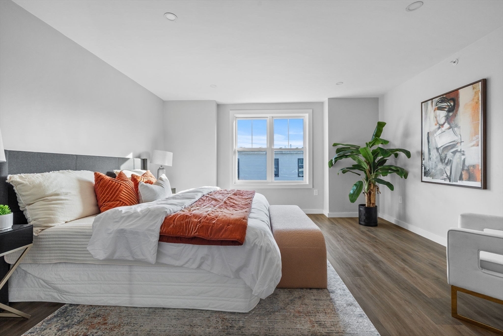 33 Copeland Street, Unit CC Boston, MA 02119 - Photo 15 of 22 a bedroom with a large bed a potted plant and a window