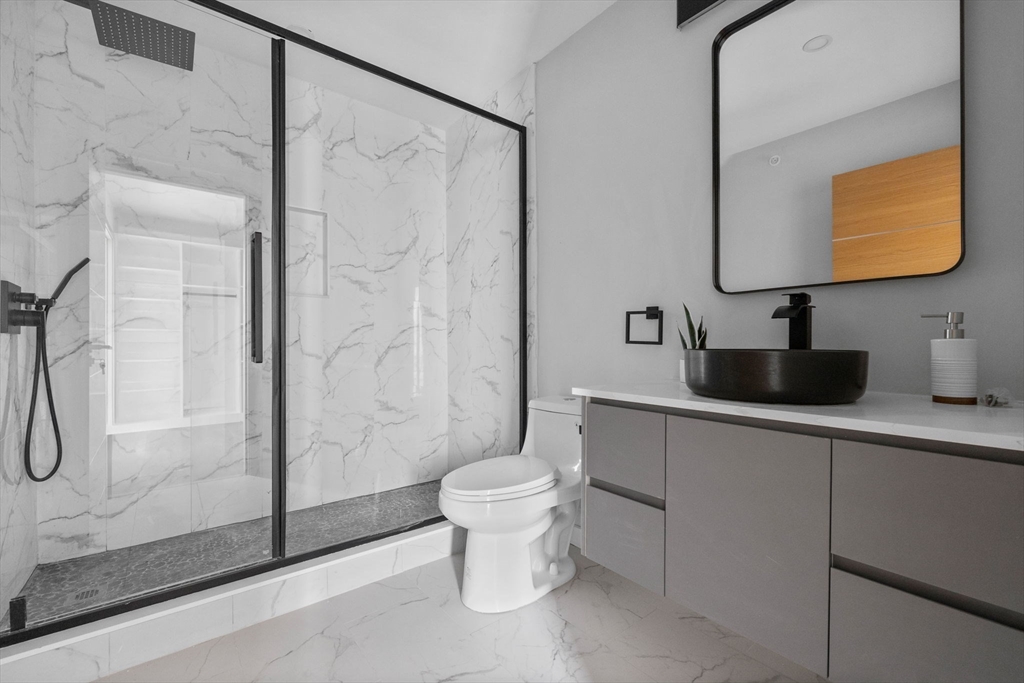 33 Copeland Street, Unit CC Boston, MA 02119 - Photo 17 of 22 a bathroom with a toilet sink and mirror