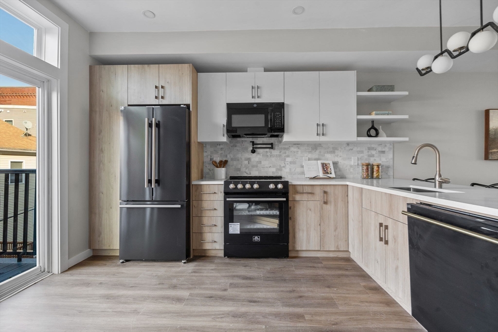 33 Copeland Street, Unit CC Boston, MA 02119 - Photo 4 of 22 a kitchen with cabinets stainless steel appliances and a window