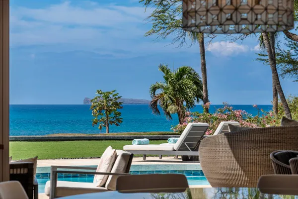 an outdoor sitting area with furniture and umbrella