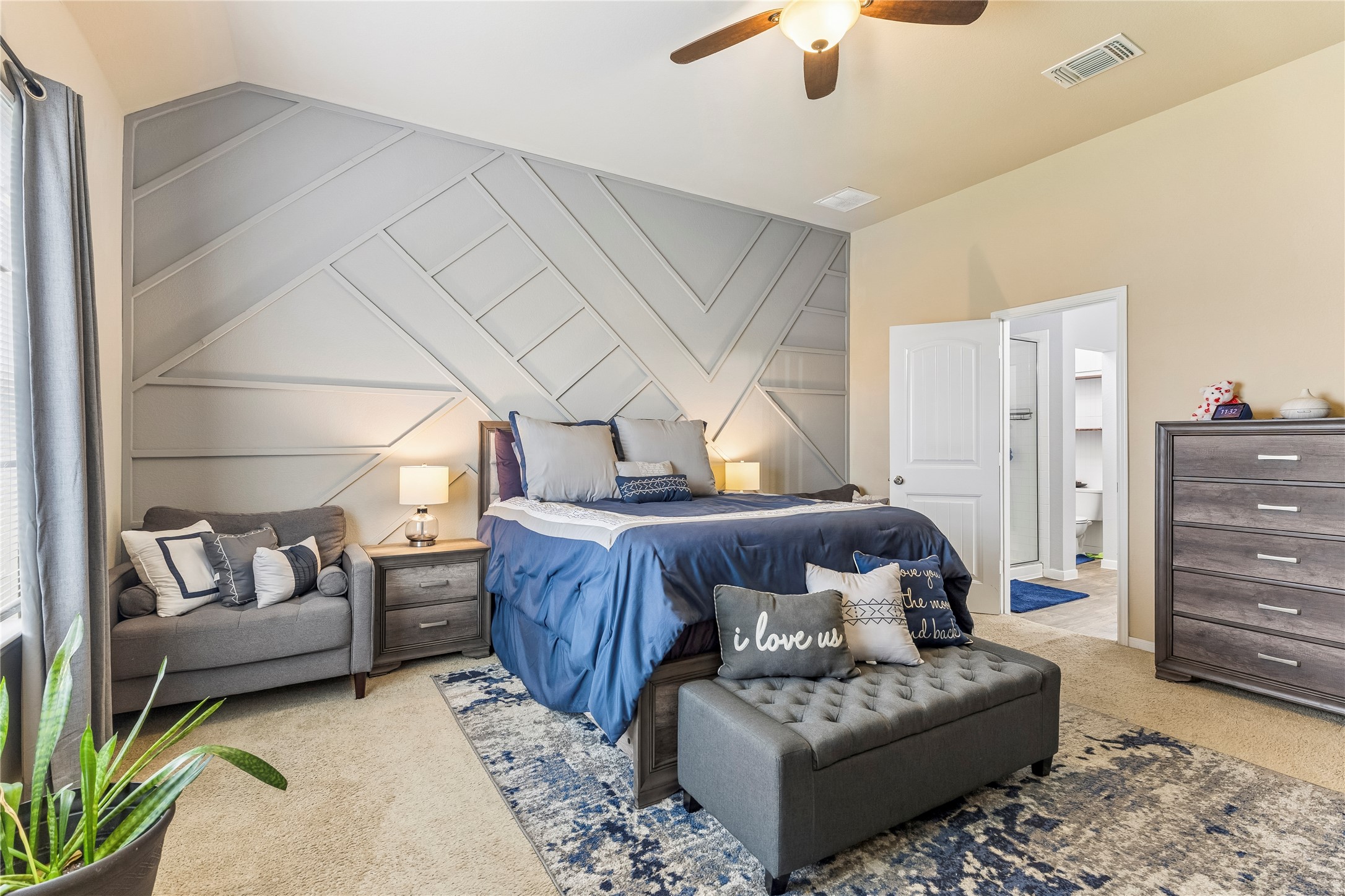 14409 Estuary Road Manor, TX 78653 - Photo 9 of 24 Accent wall featuring geometric paneling and a ceiling fan