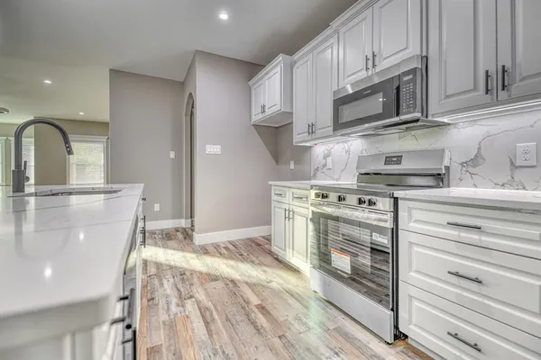 a kitchen with kitchen island a sink stainless steel appliances and cabinets