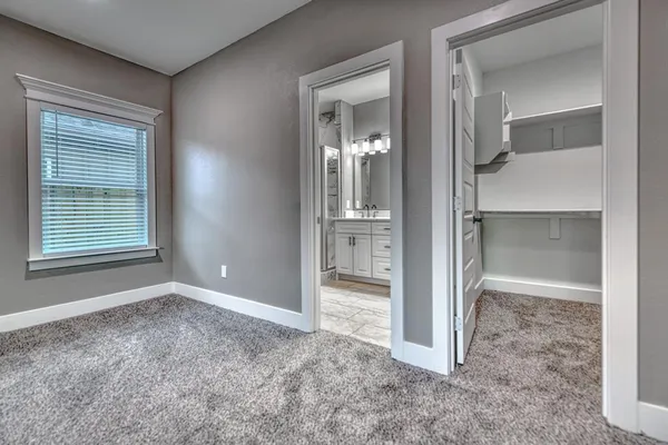 a view of an empty room with cabinet and a window