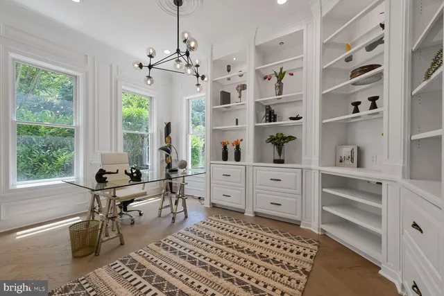 a large white kitchen with a large window and stainless steel appliances