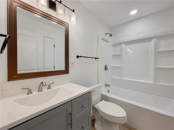 a bathroom with a sink toilet vanity and shower