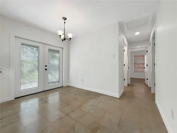a view of a hallway with wooden floor and a bathroom