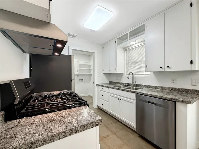 a kitchen with stainless steel appliances granite countertop a stove and a sink