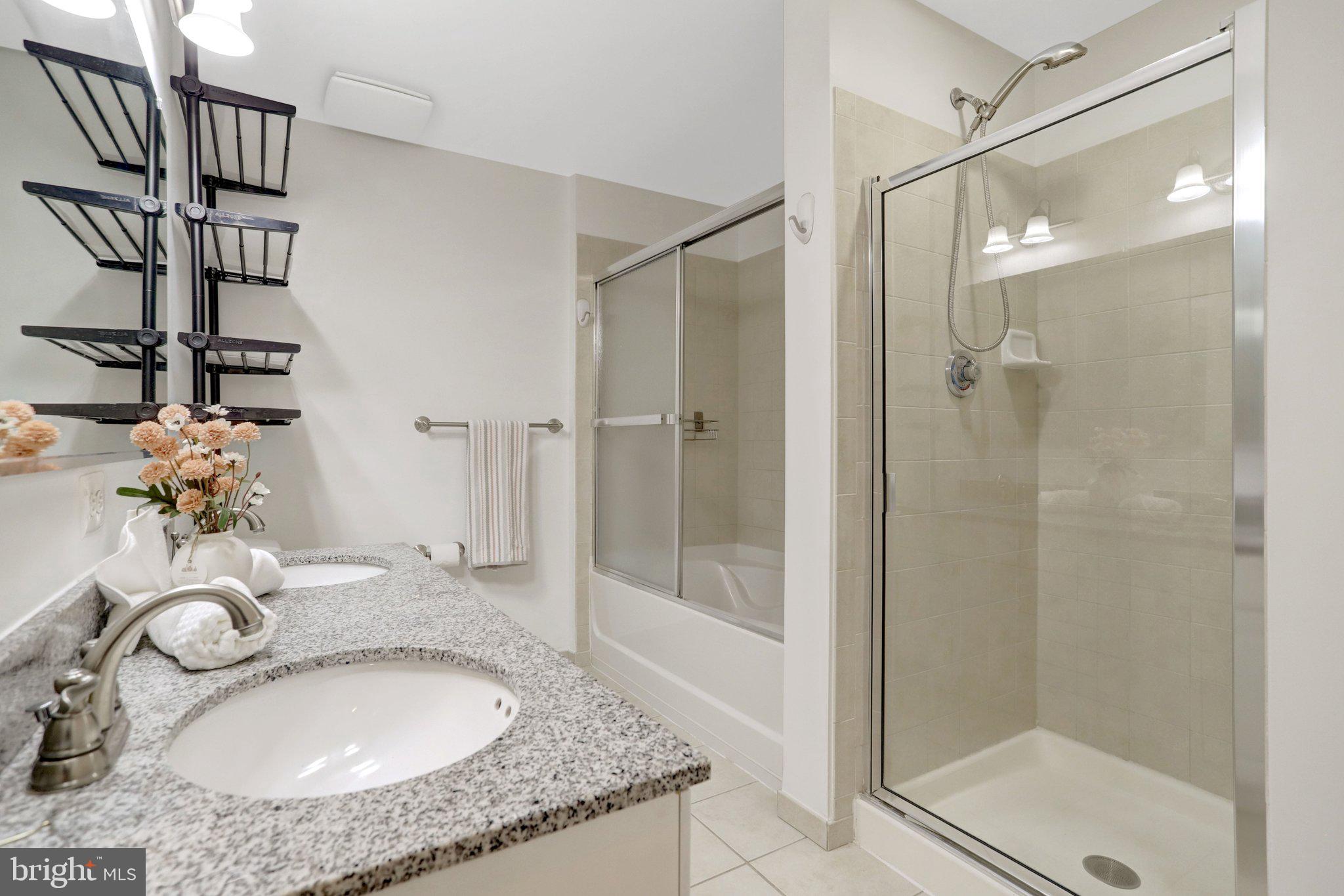 3650 South Glebe Road, Unit 442 Arlington, VA 22202 - Photo 32 of 54 a bathroom with a granite countertop sink a mirror and shower